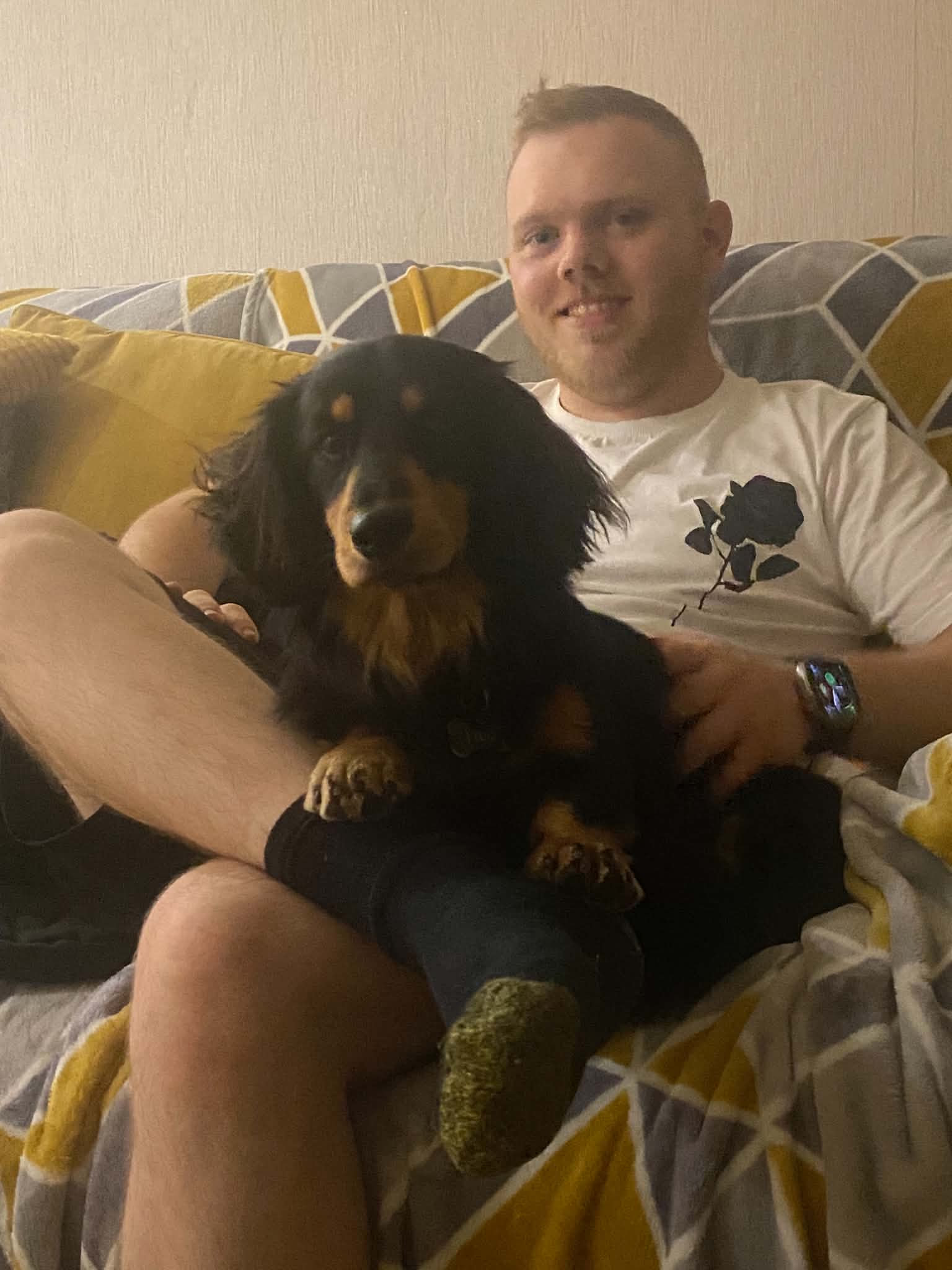 Dan relaxing with a long-haired dachshund on his lap