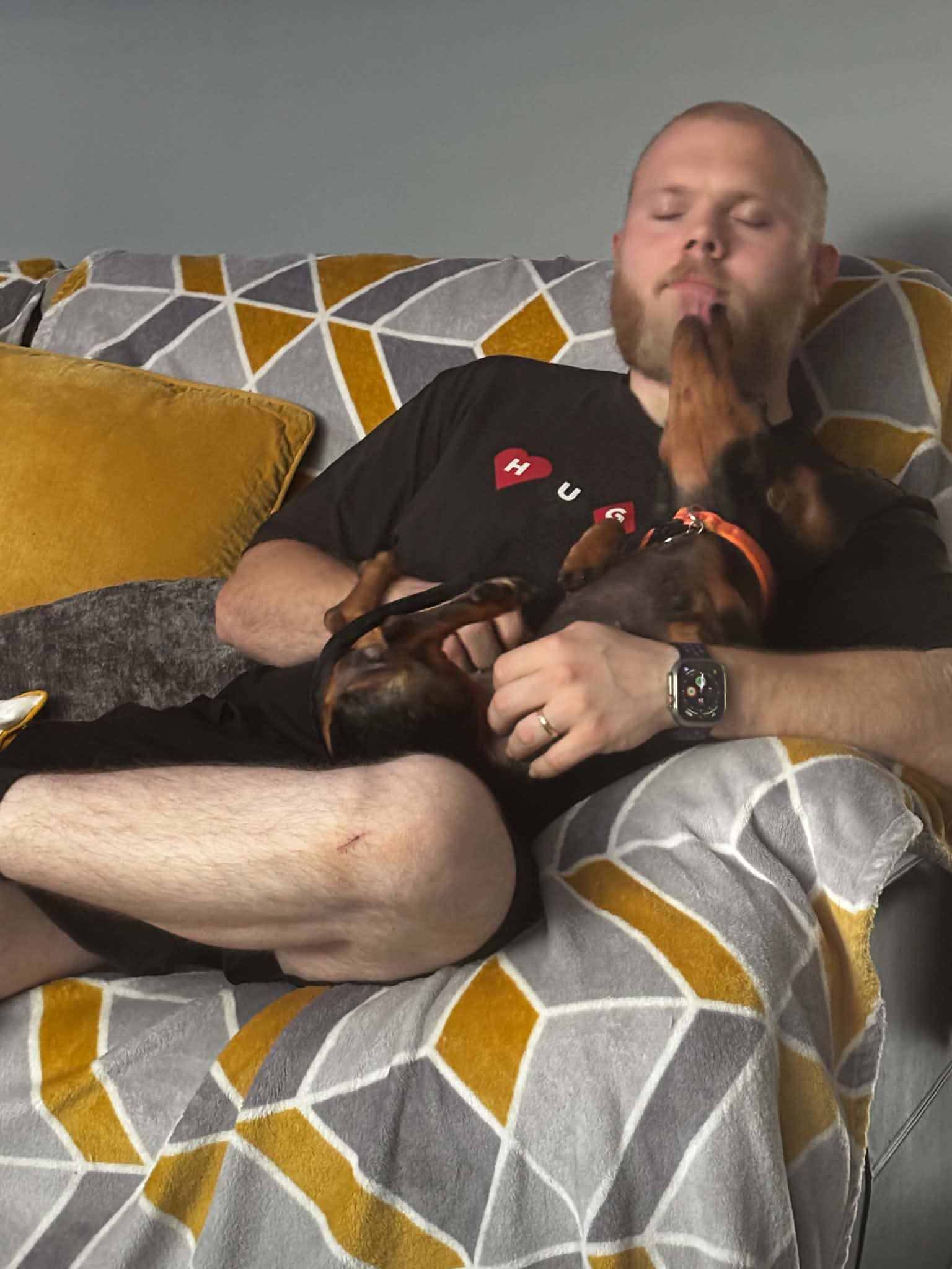 Dan receiving a dachshund kiss during sofa cuddles