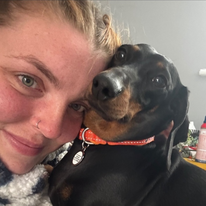 Katie cuddling a black and tan dachshund
