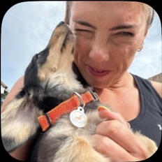Sarah sharing a cuddle with a dachshund