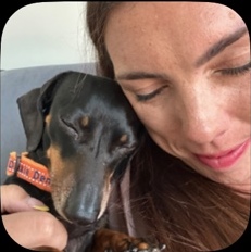 Sarah relaxing with a black and tan dachshund