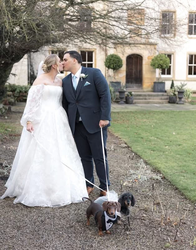 A wedding couple with their two dachshunds